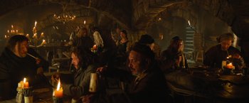 Movie still from “Hansel & Gretel: Witch Hunters” (2013), directed by Tommy Wirkola – A group of people sitting in a room with candles; Wide shot, High angle