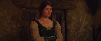 Movie still from “Hansel & Gretel: Witch Hunters” (2013), directed by Tommy Wirkola – A woman standing in front of a wooden wall; Medium shot, Over the shoulder angle