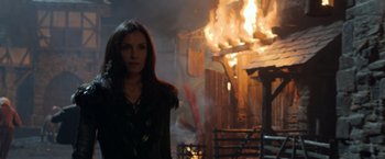 Movie still from “Hansel & Gretel: Witch Hunters” (2013), directed by Tommy Wirkola – A woman standing in front of a burning building; Medium shot, Over the shoulder angle