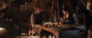 Movie still from “Hansel & Gretel: Witch Hunters” (2013), directed by Tommy Wirkola – Two people sitting at a wooden table in a room; Medium shot, High angle