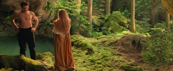 Movie still from “Hansel & Gretel: Witch Hunters” (2013), directed by Tommy Wirkola – A woman standing in the middle of a lush green forest; Wide shot, High angle