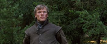 Movie still from “Hansel & Gretel: Witch Hunters” (2013), directed by Tommy Wirkola – A man standing in front of a tree looking to his left; Close Up shot, Low angle