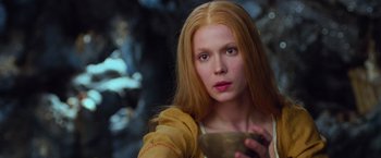 Movie still from “Hansel & Gretel: Witch Hunters” (2013), directed by Tommy Wirkola – A beautiful young lady holding a bowl while standing in front of a forest; Close Up shot, Low angle