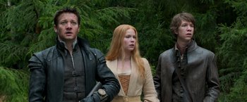 Movie still from “Hansel & Gretel: Witch Hunters” (2013), directed by Tommy Wirkola – A woman with long red hair standing between two men; Medium shot, Low angle