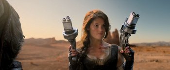 Movie still from “Hansel & Gretel: Witch Hunters” (2013), directed by Tommy Wirkola – A woman holding a wrench while standing on a dirt field; Close Up shot, Low angle