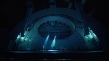 Movie still from “Happier Than Ever: A Love Letter to Los Angeles” (2021), directed by Patrick Osborne – A stage lit up with spotlights in the dark; Extreme Wide shot, High angle