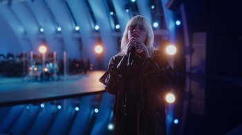 Movie still from “Happier Than Ever: A Love Letter to Los Angeles” (2021), directed by Patrick Osborne – A woman holding a microphone in front of a mirror; Wide shot, High angle