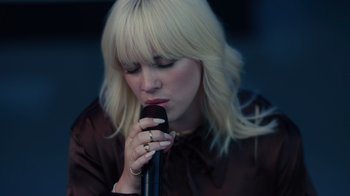 Movie still from “Happier Than Ever: A Love Letter to Los Angeles” (2021), directed by Patrick Osborne – A woman holding a microphone up to her mouth; Close Up shot, Low angle