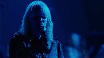Movie still from “Happier Than Ever: A Love Letter to Los Angeles” (2021), directed by Patrick Osborne – A woman singing into a microphone on a stage; Close Up shot, Low angle