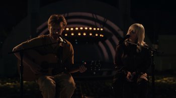 Movie still from “Happier Than Ever: A Love Letter to Los Angeles” (2021), directed by Patrick Osborne – A man and a woman playing guitar and singing; Wide shot, Over the shoulder angle