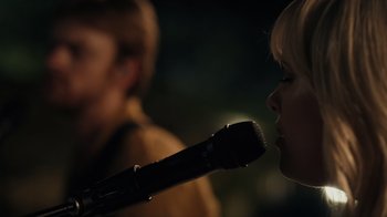 Movie still from “Happier Than Ever: A Love Letter to Los Angeles” (2021), directed by Patrick Osborne – A woman holding a microphone up to her mouth; Close Up shot, Over the shoulder angle
