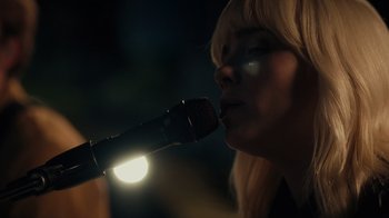 Movie still from “Happier Than Ever: A Love Letter to Los Angeles” (2021), directed by Patrick Osborne – A woman with blonde hair is holding a microphone up to her mouth; Close Up shot, Low angle