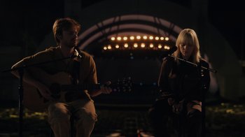Movie still from “Happier Than Ever: A Love Letter to Los Angeles” (2021), directed by Patrick Osborne – A man and a woman are playing a guitar; Wide shot, High angle