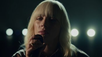 Movie still from “Happier Than Ever: A Love Letter to Los Angeles” (2021), directed by Patrick Osborne – A woman with blonde hair is holding a cell phone; Close Up shot, Low angle