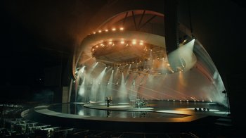 Movie still from “Happier Than Ever: A Love Letter to Los Angeles” (2021), directed by Patrick Osborne – A stage that has lights on it and people standing on it; Extreme Wide shot, High angle