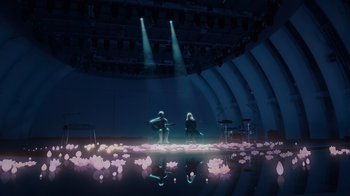 Movie still from “Happier Than Ever: A Love Letter to Los Angeles” (2021), directed by Patrick Osborne – A couple of people that are sitting on a stage; Extreme Wide shot, High angle