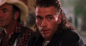 Movie still from “Hard Target” (1993), directed by John Woo – A person with long hair; Close Up shot, Over the shoulder angle