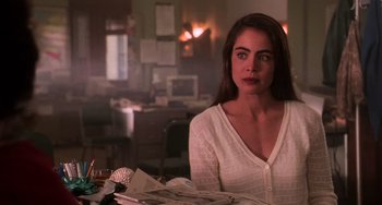 Movie still from “Hard Target” (1993), directed by John Woo – A woman sitting at a table with papers in front of her; Close Up shot, Over the shoulder angle