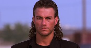 Movie still from “Hard Target” (1993), directed by John Woo – A person with long hair; Close Up shot, Low angle