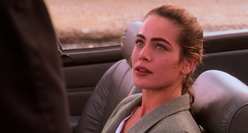 Movie still from “Hard Target” (1993), directed by John Woo – A woman sitting in the back seat of a car; Close Up shot, Over the shoulder angle