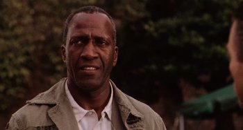 Movie still from “Hard Target” (1993), directed by John Woo – A person wearing a shirt and jacket; Close Up shot, Low angle