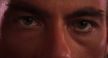 Movie still from “Hard Target” (1993), directed by John Woo – A man's eyes with green eyes; Extreme Close Up shot, Overhead angle