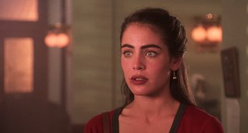 Movie still from “Hard Target” (1993), directed by John Woo – A beautiful woman in a red shirt looking at the camera; Close Up shot, Over the shoulder angle