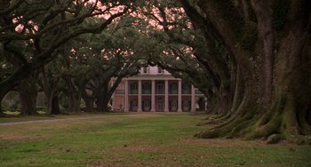 Movie still from “Hard Target” (1993), directed by John Woo – A large house in the middle of a forest; Extreme Wide shot, Low angle