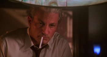 Movie still from “Hard Target” (1993), directed by John Woo – An older man with a cigarette in his mouth; Close Up shot, Low angle