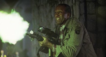 Movie still from “Hard Target” (1993), directed by John Woo – A man holding a gun in his hands; Medium shot, Low angle