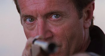 Movie still from “Hard Target” (1993), directed by John Woo – A man's face with a pen in his mouth; Extreme Close Up shot, Low angle