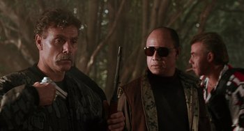 A man holding a gun next to another man