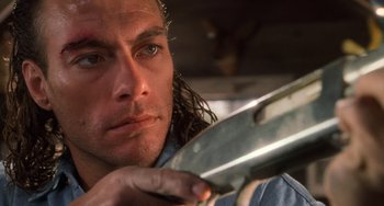 Movie still from “Hard Target” (1993), directed by John Woo – A person holding a knife; Close Up shot, Low angle