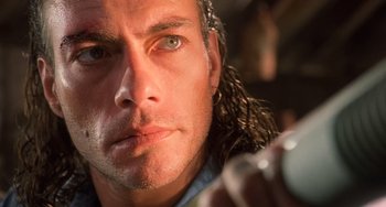 Movie still from “Hard Target” (1993), directed by John Woo – A man with long hair; Close Up shot, Low angle