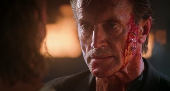 Movie still from “Hard Target” (1993), directed by John Woo – A person with blood on his face; Close Up shot, Over the shoulder angle