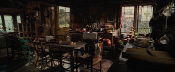 Movie still from “Harry Potter and the Chamber of Secrets” (2002), directed by Chris Columbus – An old fashioned kitchen with a table , chairs , and a stove; Wide shot, High angle