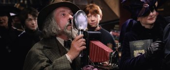 Movie still from “Harry Potter and the Chamber of Secrets” (2002), directed by Chris Columbus – A man holding a light bulb in front of another man; Close Up shot, Low angle