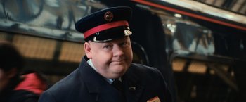 Movie still from “Harry Potter and the Chamber of Secrets” (2002), directed by Chris Columbus – A man wearing a uniform and a red hat; Close Up shot, Low angle