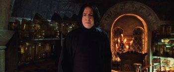 Movie still from “Harry Potter and the Chamber of Secrets” (2002), directed by Chris Columbus – A man in a black shirt is standing in front of a fire place; Close Up shot, Low angle