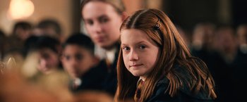 Movie still from “Harry Potter and the Chamber of Secrets” (2002), directed by Chris Columbus – A young girl with long red hair is looking at the camera; Close Up shot, High angle