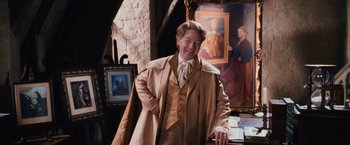 Movie still from “Harry Potter and the Chamber of Secrets” (2002), directed by Chris Columbus – A man in a suit and tie standing in front of a painting; Medium shot, Over the shoulder angle