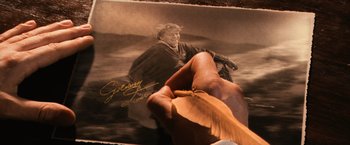 Movie still from “Harry Potter and the Chamber of Secrets” (2002), directed by Chris Columbus – A hand holding a leaf over an image of a woman; Close Up shot, High angle