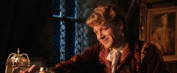 Movie still from “Harry Potter and the Chamber of Secrets” (2002), directed by Chris Columbus – A man in a red jacket smiling for the camera; Close Up shot, Over the shoulder angle