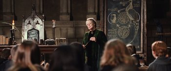 Movie still from “Harry Potter and the Chamber of Secrets” (2002), directed by Chris Columbus – An older woman in a green dress holding a wand; Medium shot, Over the shoulder angle