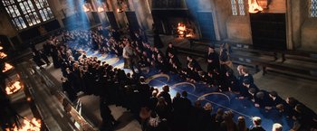 Movie still from “Harry Potter and the Chamber of Secrets” (2002), directed by Chris Columbus – A group of people sitting in front of a fireplace; Extreme Wide shot, High angle