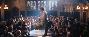 Movie still from “Harry Potter and the Chamber of Secrets” (2002), directed by Chris Columbus – A man is performing tricks in front of a crowd; Wide shot, Low angle