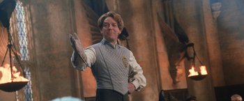 Movie still from “Harry Potter and the Chamber of Secrets” (2002), directed by Chris Columbus – A man in a gray vest and white shirt; Medium shot, Low angle