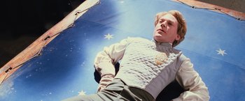 Movie still from “Harry Potter and the Chamber of Secrets” (2002), directed by Chris Columbus – A man laying on the ground wearing a vest; Medium shot, Low angle