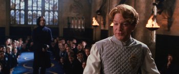 Movie still from “Harry Potter and the Chamber of Secrets” (2002), directed by Chris Columbus – A woman in a crowd of people in a room; Medium shot, Low angle