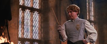 Movie still from “Harry Potter and the Chamber of Secrets” (2002), directed by Chris Columbus – A man holding a wand while wearing gloves; Medium shot, Low angle